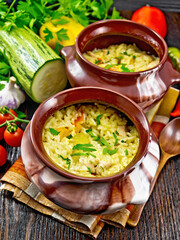 Rice with chicken and vegetables in two pots on napkin