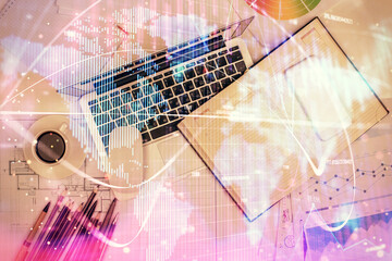Business theme hologram drawings over computer on the desktop background. Top view. Multi exposure. Concept of international connections.