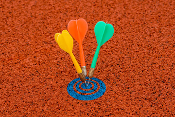 Red, green and yellow color dart arrows hits blue target