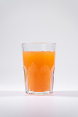 fresh cold orange fruit juice with grapefruit, ice, straw isolated