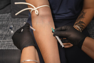 A close up of hands and blood draw process