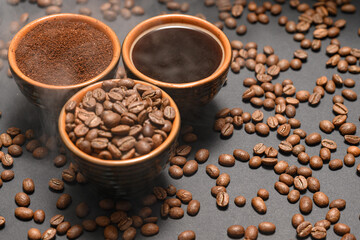 Freshly ground and prepared black coffee on a black background.