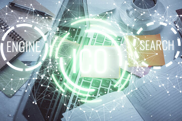 Blockchain theme hologram drawings over computer on the desktop background. Top view. Multi exposure. Concept of cryptoeconomy.