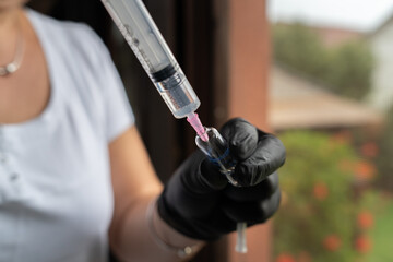 A close up of needle using cure from bottle preparing for vaccination 