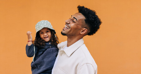 Happy young dad celebrating father's day with his daughter in a studio