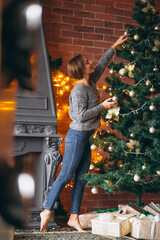 Pretty woman decorating Christmas tree