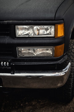 Closeup photo of the front of a black car. 