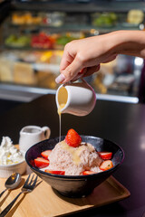 Cloes up Bingsu Strawberry milk and Strawberry Serve with sweetened condensed milk and chocolate