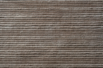 Texture backdrop of beige colored corduroy fabric cloth. Corduroy retro fabric background or texture. Closeup view