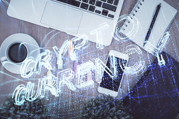 Double exposure of blockchain theme hologram over table with phone. Top view. Crypto technology concept.