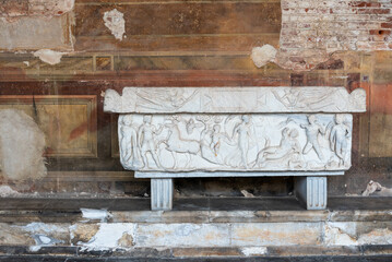 Decorated ancient roman marble tomb inside old room in ruins in Pisa