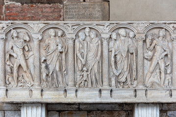 Roman characters carved in marble wall decorating monument in Pisa