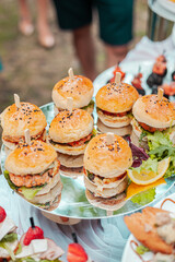 Small burgers with meat and sesame seeds on a platter