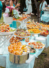 Festive table with buffet appetizers decorated with flowers