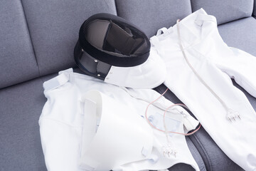 fencing mask and fencing suit on the couch