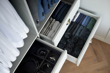 Man cupboard clothes storage organization neatly folded belt underwear shirt and socks
