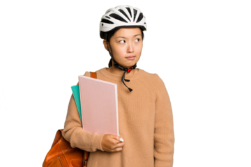 Young student asian woman wearing a bike helmet isolated on green chroma background confused, feels doubtful and unsure.