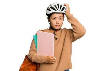 Young student asian woman wearing a bike helmet isolated on green chroma background being shocked, she has remembered important meeting.