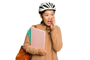 Young student asian woman wearing a bike helmet isolated on green chroma background shouting and holding palm near opened mouth.