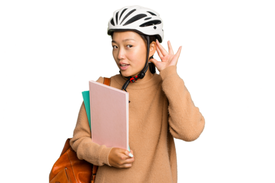 Young student asian woman wearing a bike helmet isolated on green chroma background trying to listening a gossip.