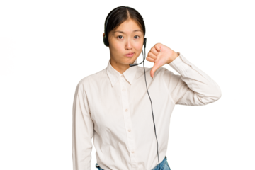 Telemarketer asian woman working with a headset isolated on green chroma background showing a dislike gesture, thumbs down. Disagreement concept.
