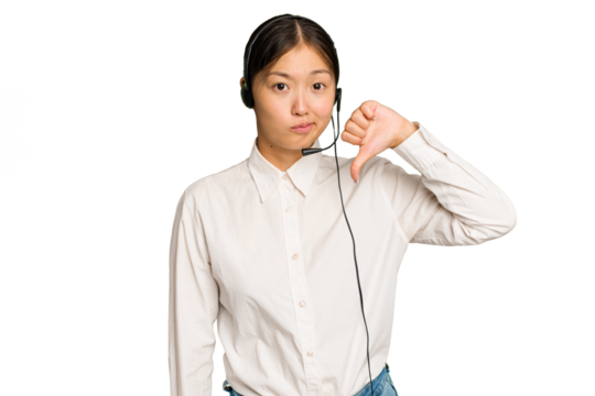 Telemarketer asian woman working with a headset isolated on green chroma background showing a dislike gesture, thumbs down. Disagreement concept.