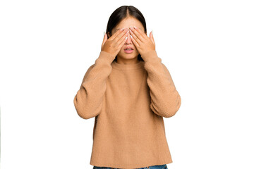 Young Asian woman isolated on green chroma background afraid covering eyes with hands.