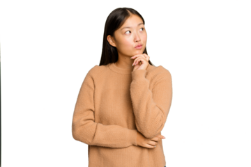 Young Asian woman isolated on green chroma background thinking and looking up, being reflective, contemplating, having a fantasy.