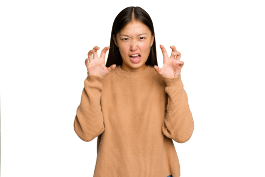 Young Asian woman isolated on green chroma background showing claws imitating a cat, aggressive gesture.