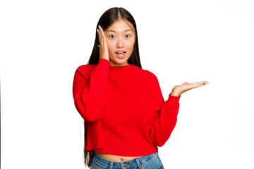 Young Asian woman isolated on green chroma background impressed holding copy space on palm.