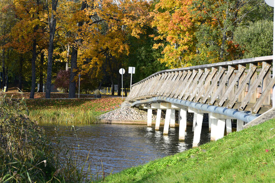 a beautiful bridge over the river where colorful autumn leaves can be seen in the distance