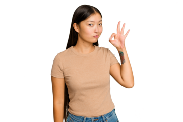 Young Asian woman isolated on green chroma background winks an eye and holds an okay gesture with hand.