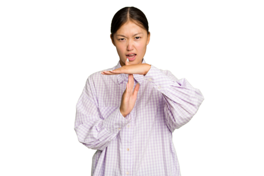 Young Asian woman isolated on green chroma background showing a timeout gesture.