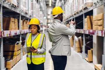Portrait two african american engineer team shipping order detail on tablet check goods and supplies on shelves with goods inventory in factory warehouse.logistic industry and business export
