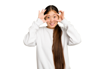 Young Asian woman isolated on green chroma background keeping eyes opened to find a success opportunity.