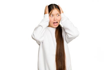 Young Asian woman isolated on green chroma background covering ears with hands trying not to hear too loud sound.