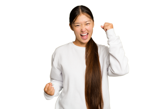 Young Asian woman isolated on green chroma background cheering carefree and excited. Victory concept.