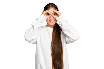 Young Asian woman isolated on green chroma background showing okay sign over eyes