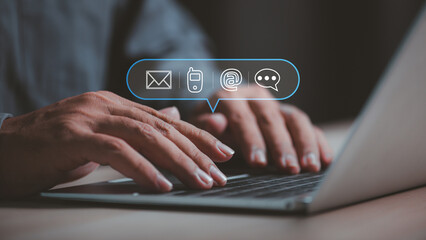 businessman hand using laptop with contact icons  for call support on virtual screen , man select customer support channel (telehpone, mobile , email or chat message)