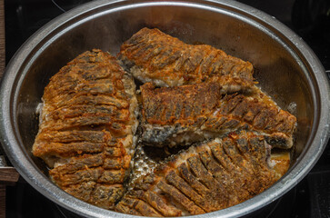 The cook fries fresh crucian fish in a frying pan	
