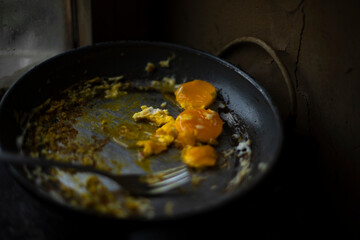 Egg yolk in frying pan. Plug and egg. Steel frying pan. Kitchen at home.