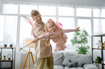Father and daughter wearing fairies costume having fun - Powered by Adobe