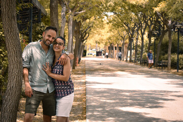 Pareja de enamorados chico y chica en un paseo rodeado de árboles en otoño