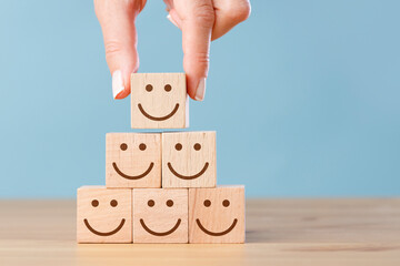 Business service rating, customer satisfaction concept. Smiley faces on wooden cubes.