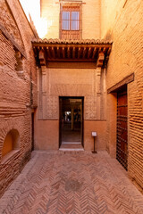 Fototapeta na wymiar House in tinghir, traditional house of clay and straw. Earth house with blue steel doors. One door open.