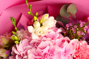 Beautiful bouquet of fresh roses, carnation, freesias, hydrangea, eucalyptus in tender pink and white colors, bouquet of flowers close up. Floral shop concept.