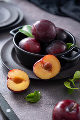 Naklejka na ściany i meble Fresh cherry plum fruits in black bowl, dark and moody food photo