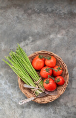 Healthy food vegetable on stone background has asparagus tomato fork top view.