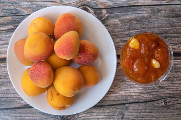 Apricots on the table and apricot jam in a glass bowl.