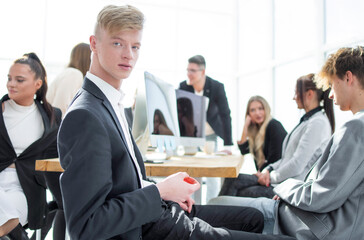 young employee sitting at a table during a work meeting.